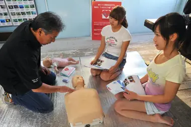 an instructor teaches two two females in emergency first response and cpr techniques