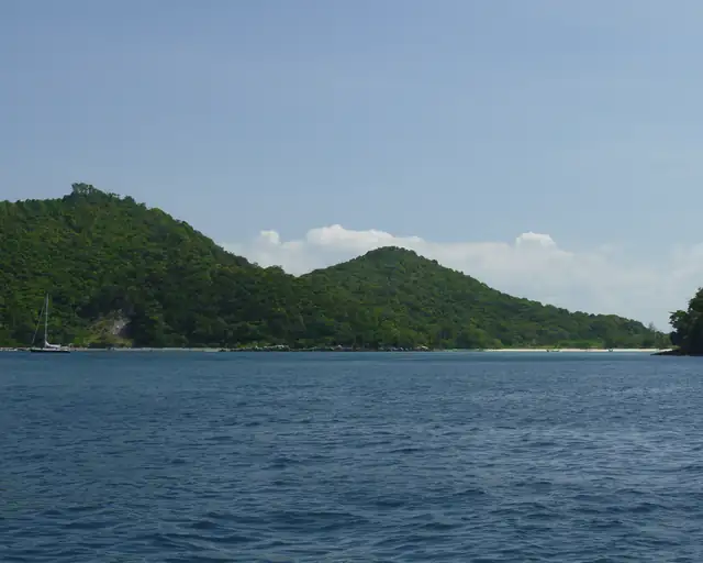 a view of Phi Phi islands in Krabi, blue sea a small beach and vegetation covered rocky hills