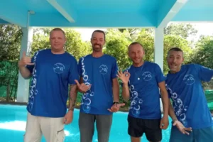 Four PADI Dive instructors in matching Sawasdee Divers t-shirts pose at the training pool